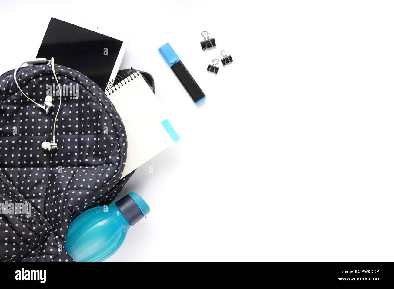 Studio roba. Sfondo dell'istruzione. Articoli di cancelleria. Gli aspetti dell'istruzione. Adesivi, marker, clip, cuffie bagpack, tablet, bottiglia e all'interno del notebook Foto Stock