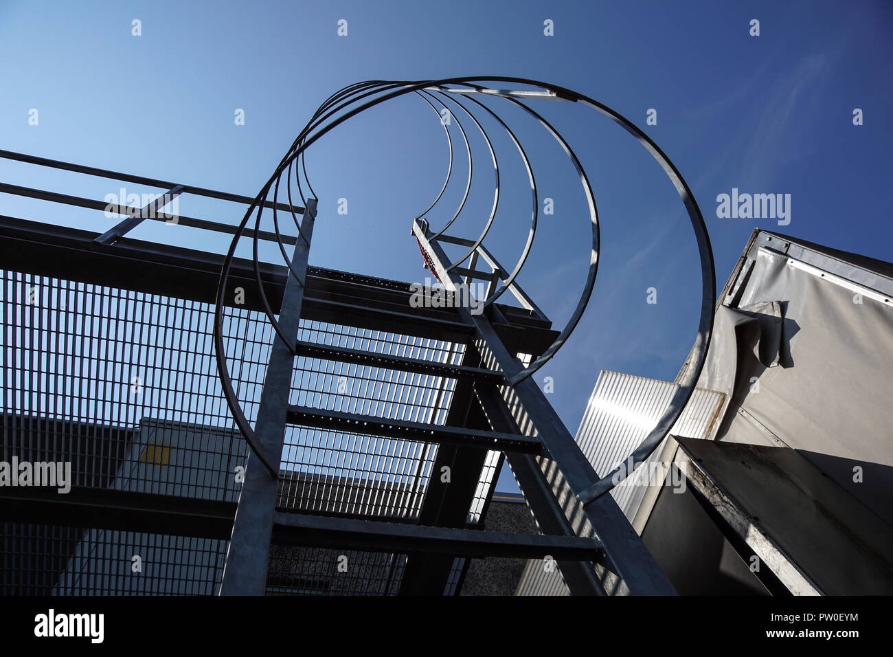 Industriali scale verticale con chiara skybackground.scala verticale dell'edificio.scaletta di acciaio con protezione. Foto Stock