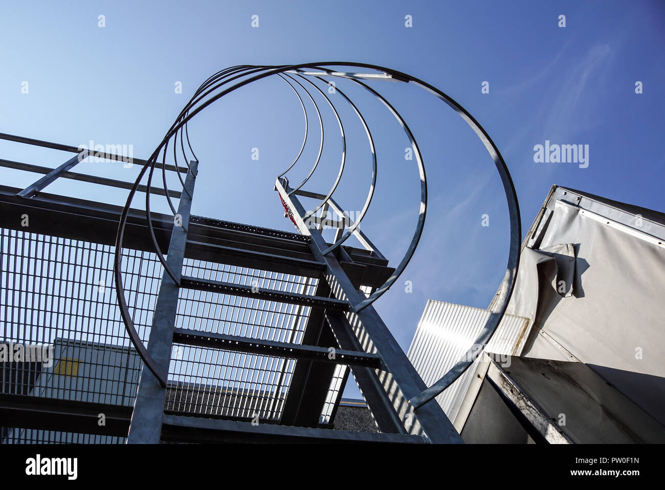 Industriali scale verticale con chiara skybackground.scala verticale dell'edificio.scaletta di acciaio con protezione. Foto Stock