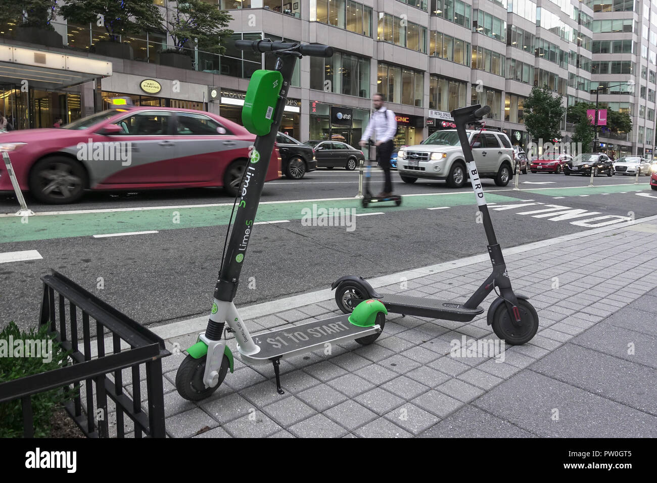 Saltare scooter pilota bikelane, 2 dockless scooter elettrici parcheggiato, Downtown DC. Calce-S & Bird dockless scooter scooter aziende operanti in c.c. Foto Stock