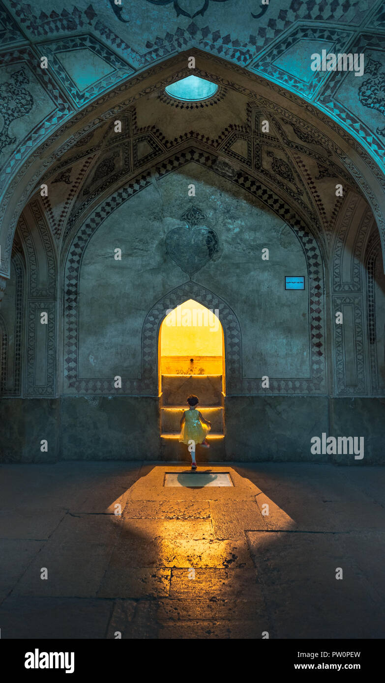 Ragazza giovane stepping nella luce del bagno turco in moschea di Tehran, Iran Foto Stock