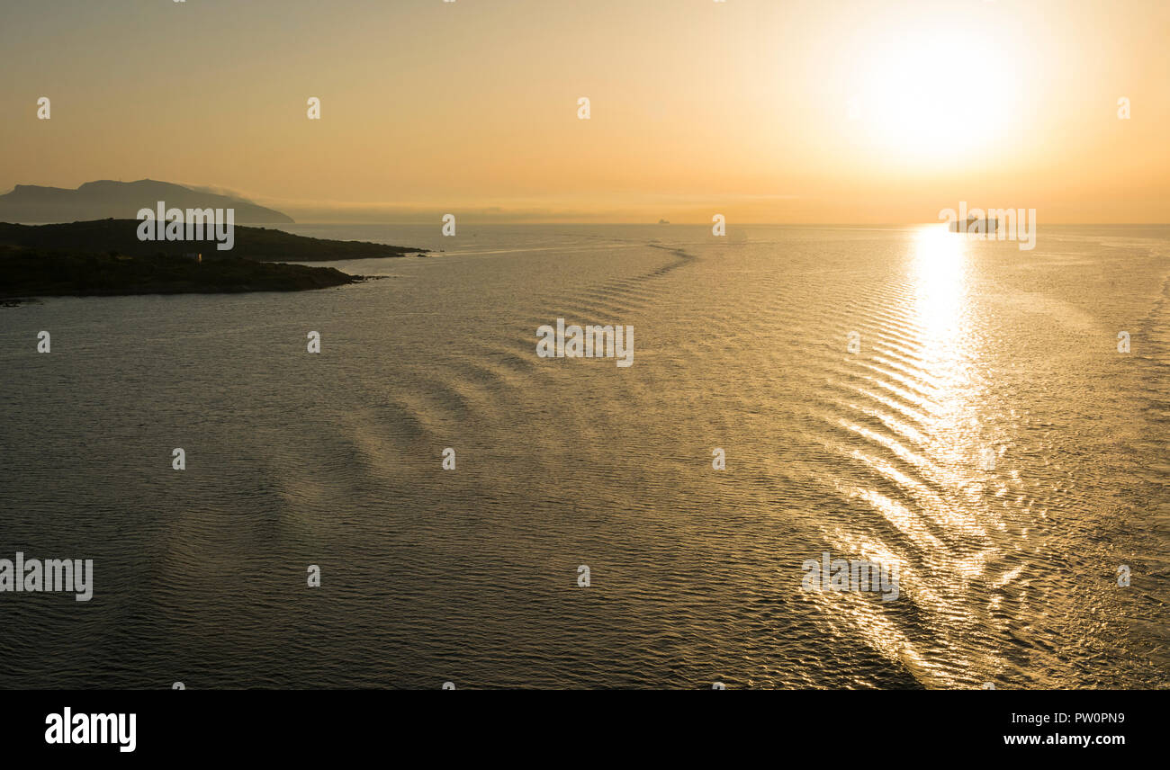 Seascape in toni di colore giallo. Una vista mozzafiato del mare di un paesaggio visto dalla costa di Olbia in Sardegna all'alba. Foto Stock