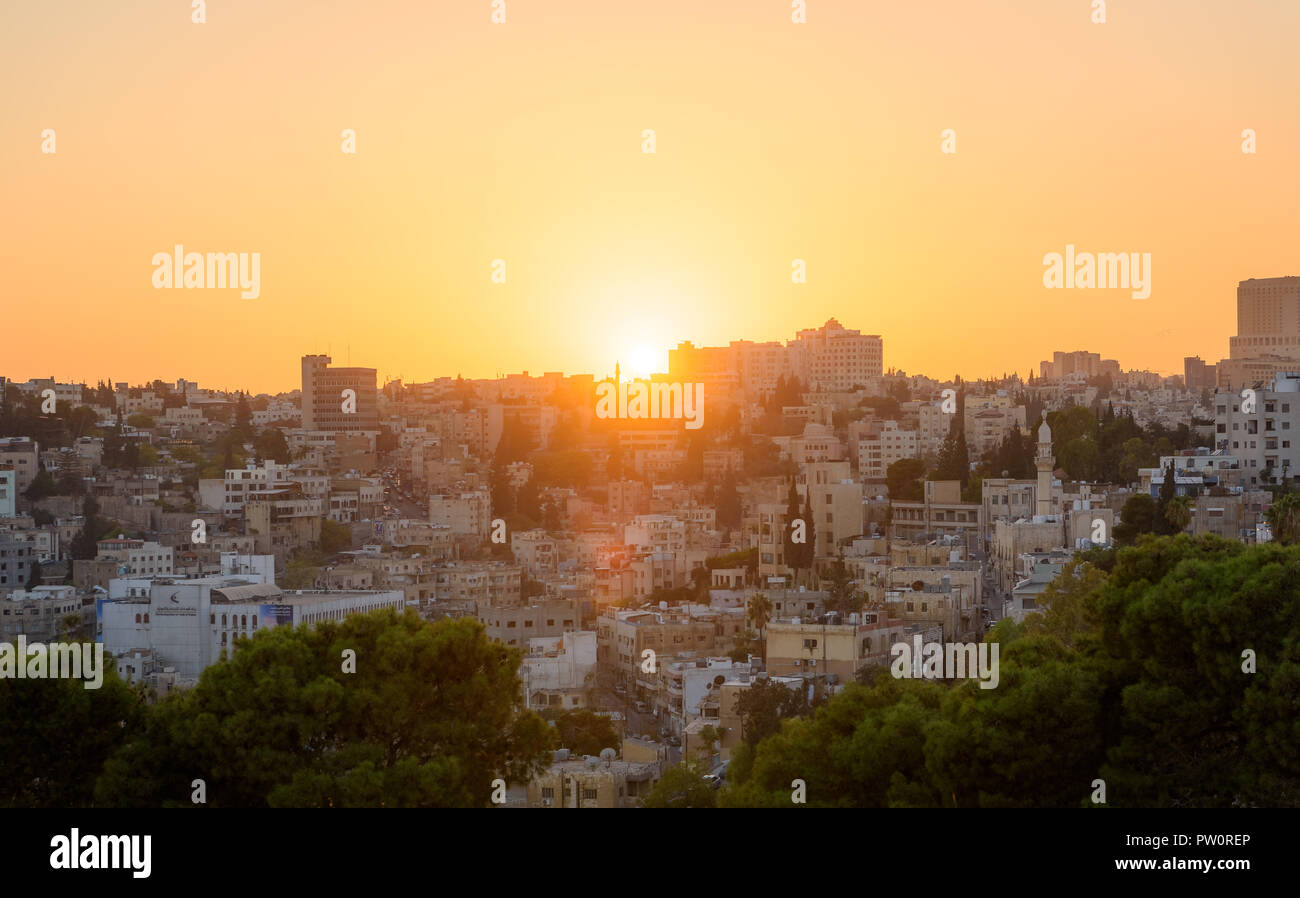 Amman, Giordania le sue rovine romane nel centro dell'antica cittadella parco nel centro della citta'. Tramonto sulla Skyline di Amman e il centro storico della città Foto Stock