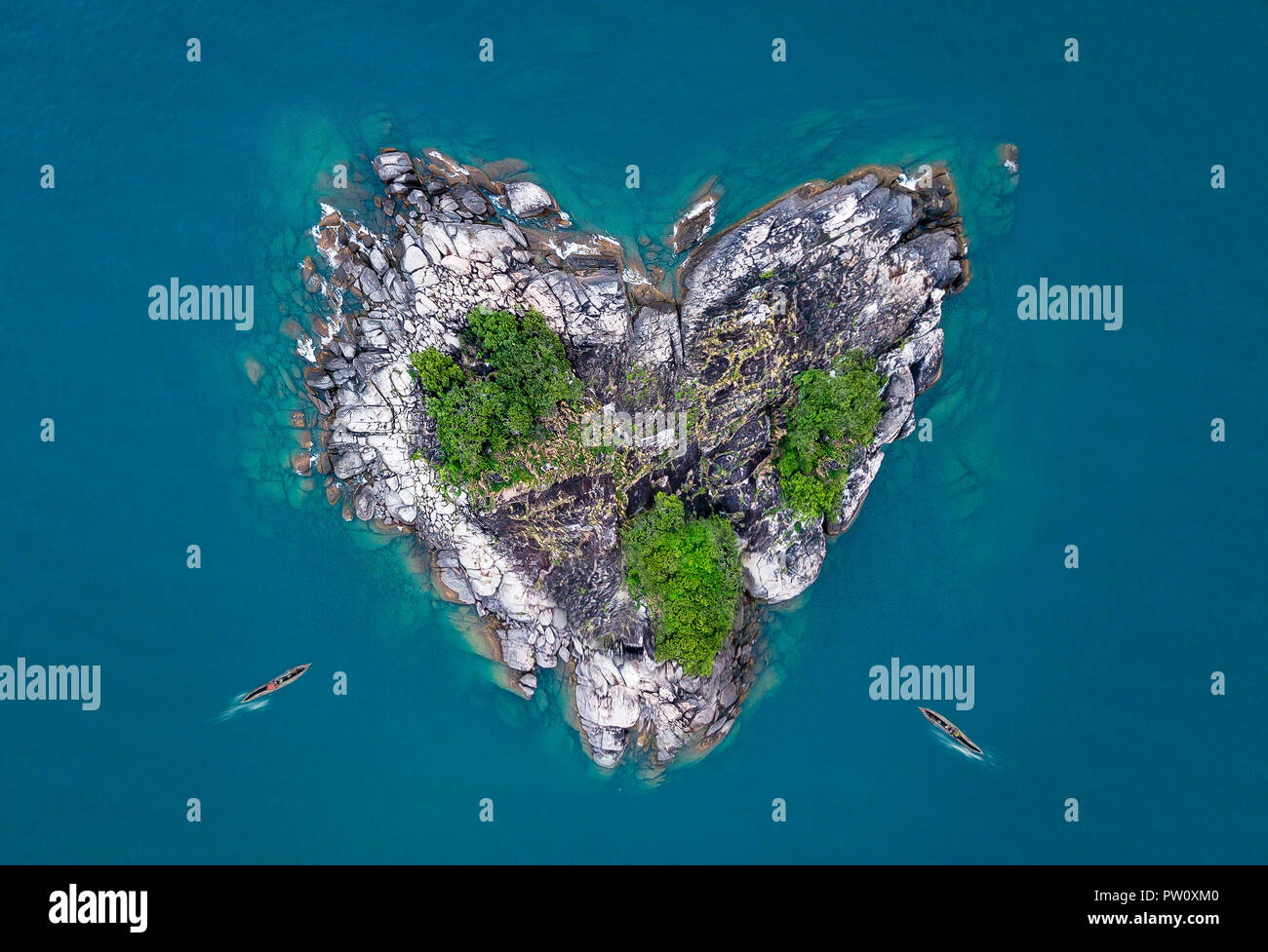 A forma di cuore ad isola, cuore isola nel lago con canoe barche peddling alle rive. Foto aerea di cuore isola nell'oceano e il Lago Malawi kande beach Foto Stock