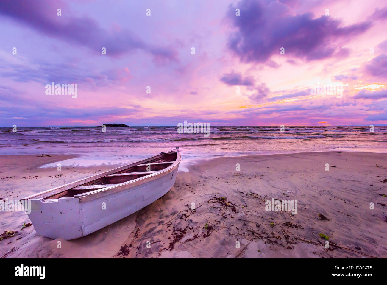 Il lago Malawi tramonto nella spiaggia di Kande Africa, canoa barca sulla spiaggia tranquilla spiaggia vacanza bellissimo tramonto colori blu porpora giallo arancione nel cielo e clou Foto Stock