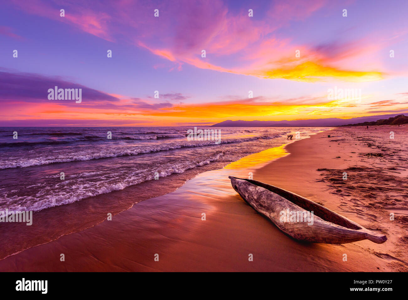Il lago Malawi tramonto nella spiaggia di Kande Africa, canoa barca sulla spiaggia tranquilla spiaggia vacanza bellissimo tramonto colori blu porpora giallo arancione nel cielo e clou Foto Stock
