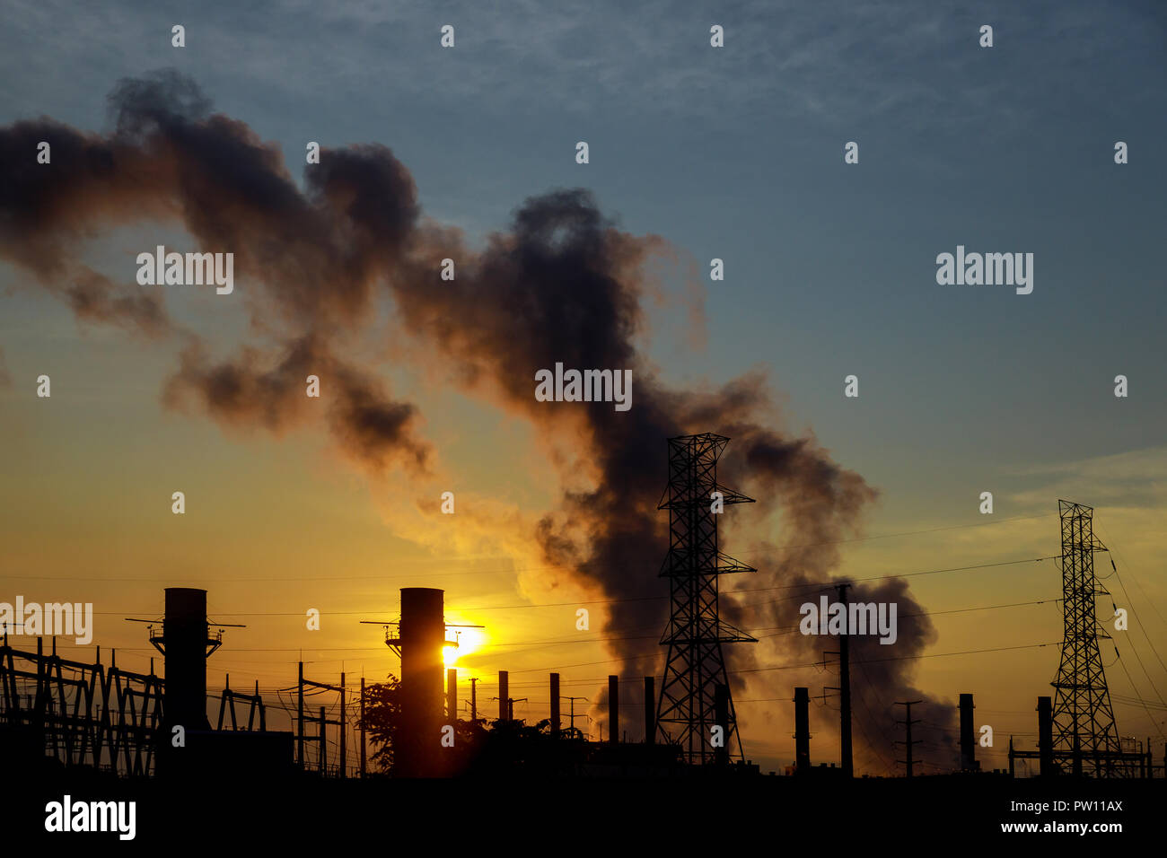 Il sole sorge oltre il carbone power station su un terribilmente freddo mattino. Foto Stock