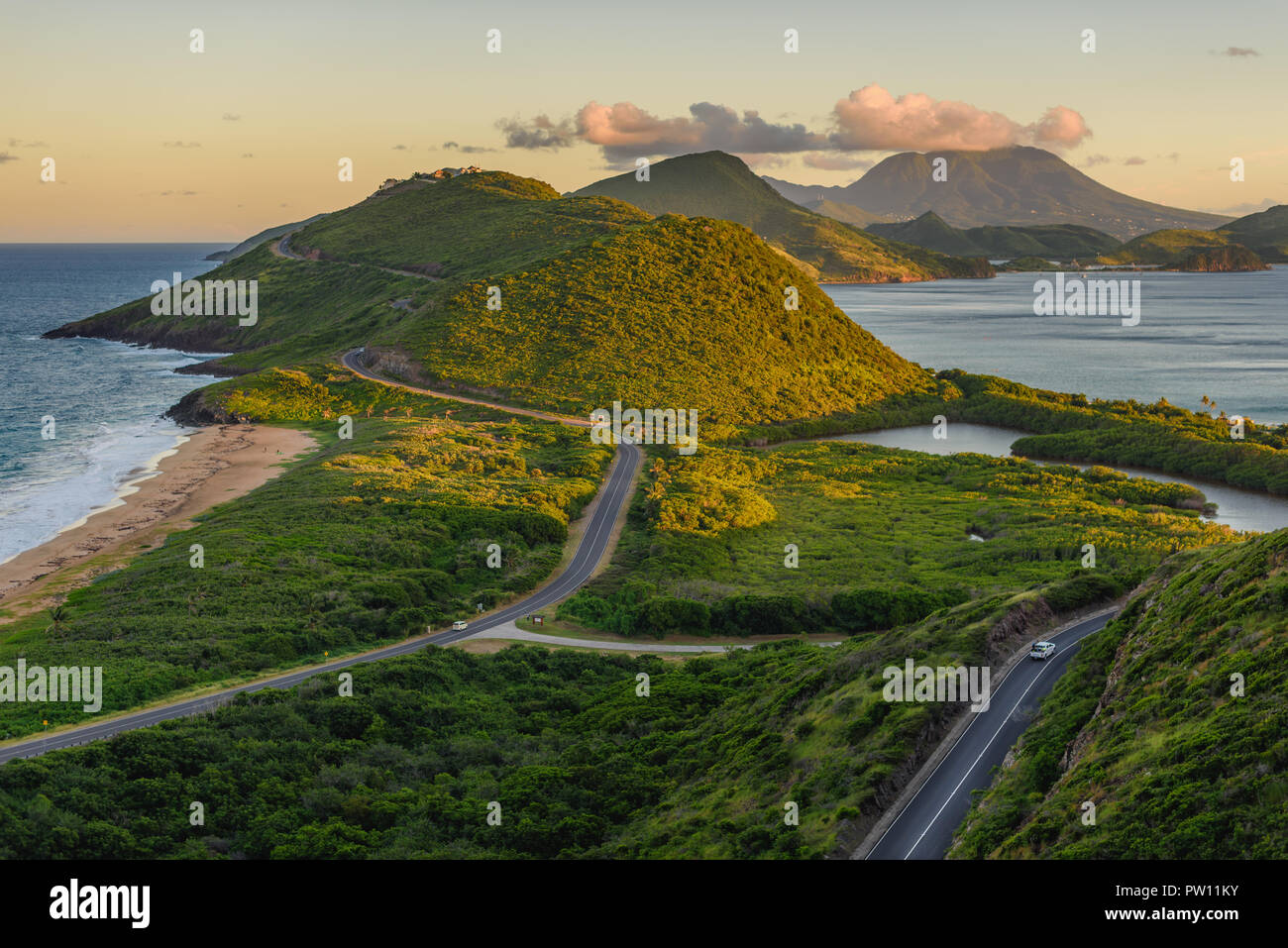 Saint Kitts montagne e punto di vista mare e vista delle strade per il sud dell'isola dei Caraibi durante il tramonto. Oceano blu e verdi lussureggianti montagne mi Foto Stock