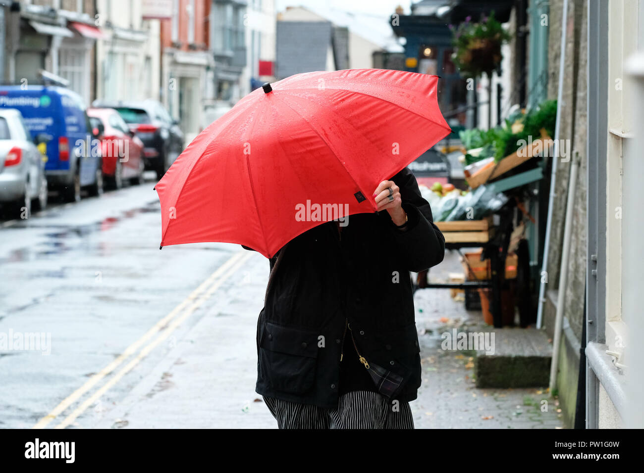 Hay-on-Wye, POWYS, GALLES - Venerdì 12 Ottobre 2018 - Una donna fa fatica a tenere sul suo ombrello come lei cammina contro il forte vento e pioggia di tempesta Callum nella città di confine di Hay-on-Wye - Photo Steven Maggio / Alamy Live News Foto Stock