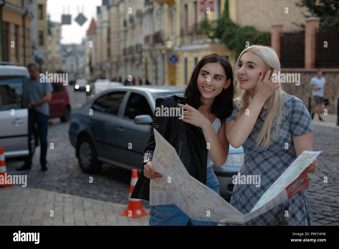 Due incantevoli allegro le donne stanno camminando con mappa Foto Stock