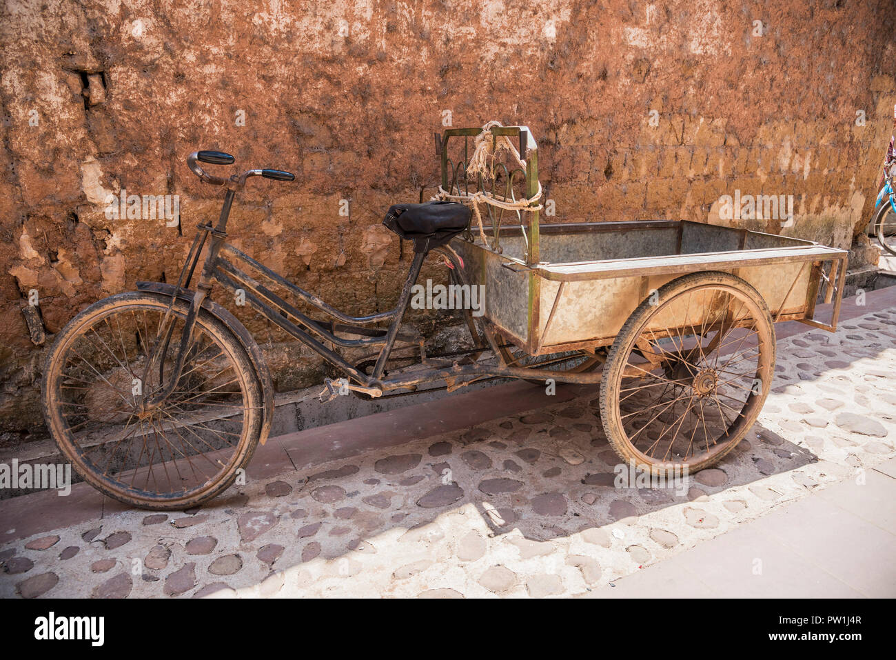 Un vecchio triciclo con rimorchio convertito in una vecchia strada rurale  nel sud ovest della Cina Foto stock - Alamy