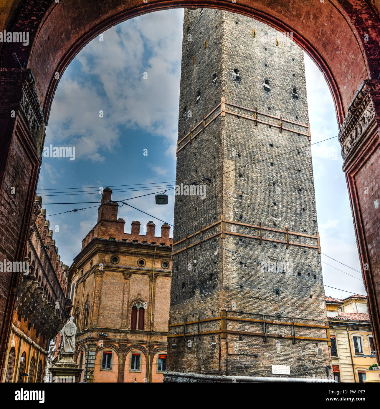 Parte inferiore della Torre della Garisenda visto attraverso un arco storico. Bologna, Italia Foto Stock