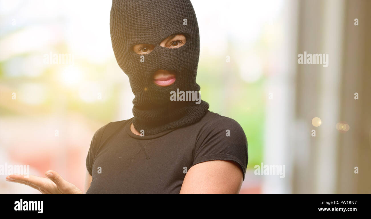 Ladro terrorista donna che indossa passamontagna maschera da sci tenendo  qualcosa in mano vuota Foto stock - Alamy