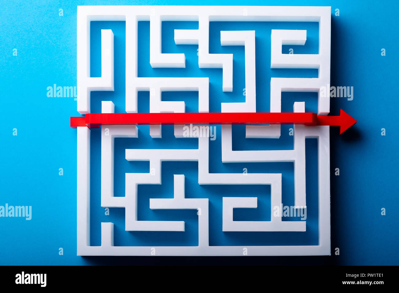 Vista in elevazione della Freccia Rossa attraversando il labirinto bianco su sfondo blu Foto Stock