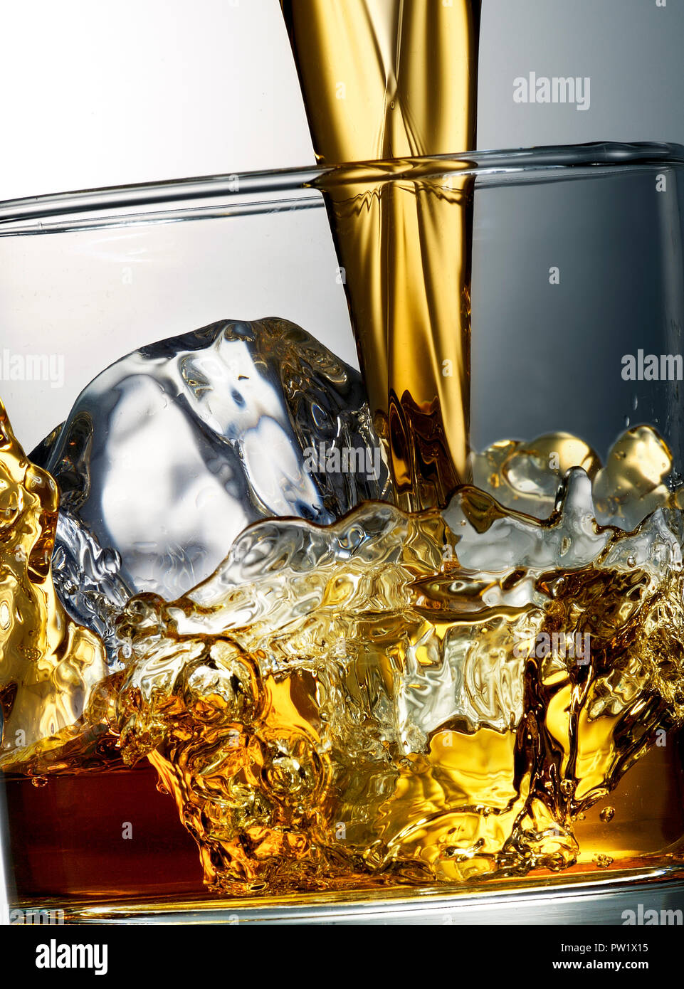 Whiskey Brandy stato riversato su un bicchiere con ghiaccio, azione di arresto, Liquori Foto Stock