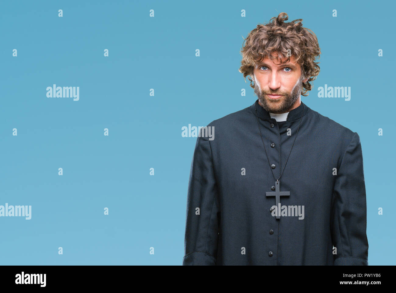 Bello ispanica sacerdote cattolico uomo sullo sfondo isolato premuto e la preoccupazione per la sofferenza, gridando arrabbiato e paura. Triste espressione. Foto Stock
