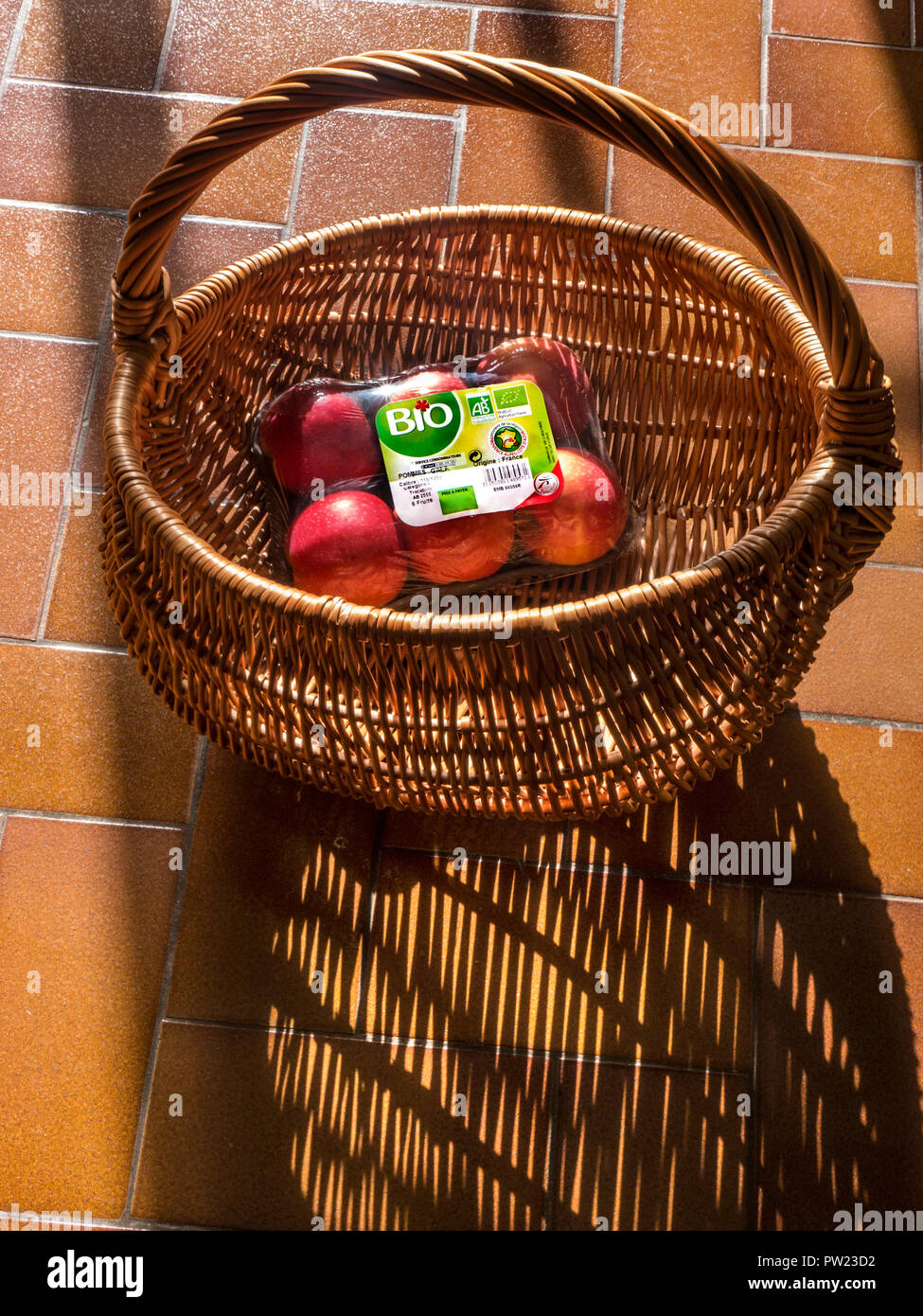 Biodinamico francese Le mele Gala in vimini carrello, nell'albero di luce solare, come un concetto per una sana vita organica frutta futura agricoltura Francia Foto Stock