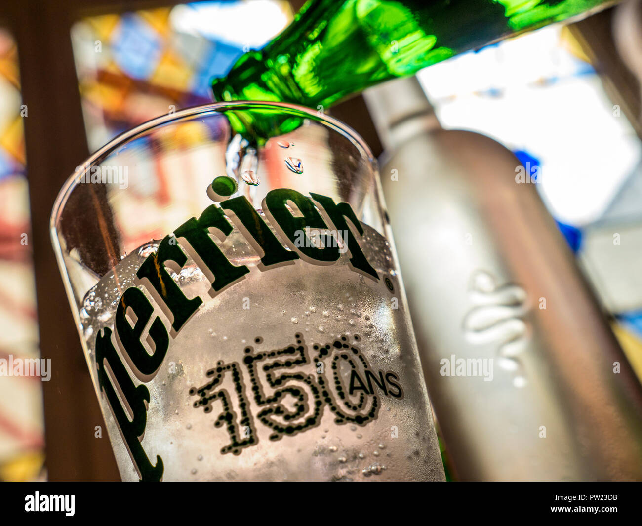 Gassata refrigerata Perrier (150 ans) acqua versando ristorante tabella situazione, con vetrate colorate e la vecchia città di Vannes dietro Brittany Finisterre Foto Stock