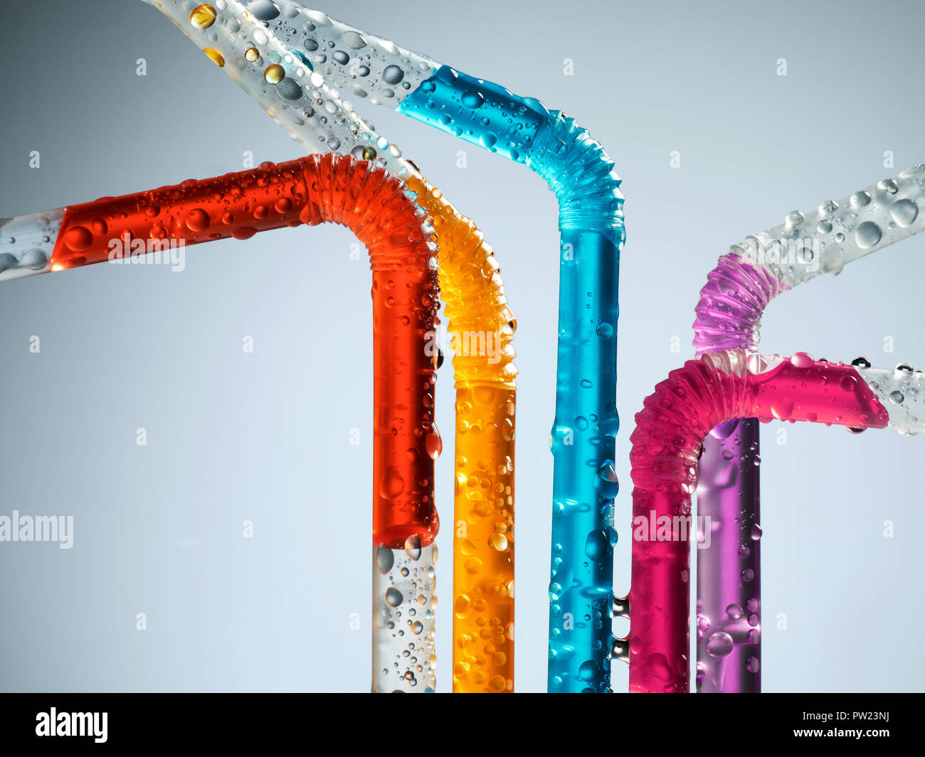 Un gruppo di cannucce colorate con liquidi colorati, estate divertente e allegro Foto Stock
