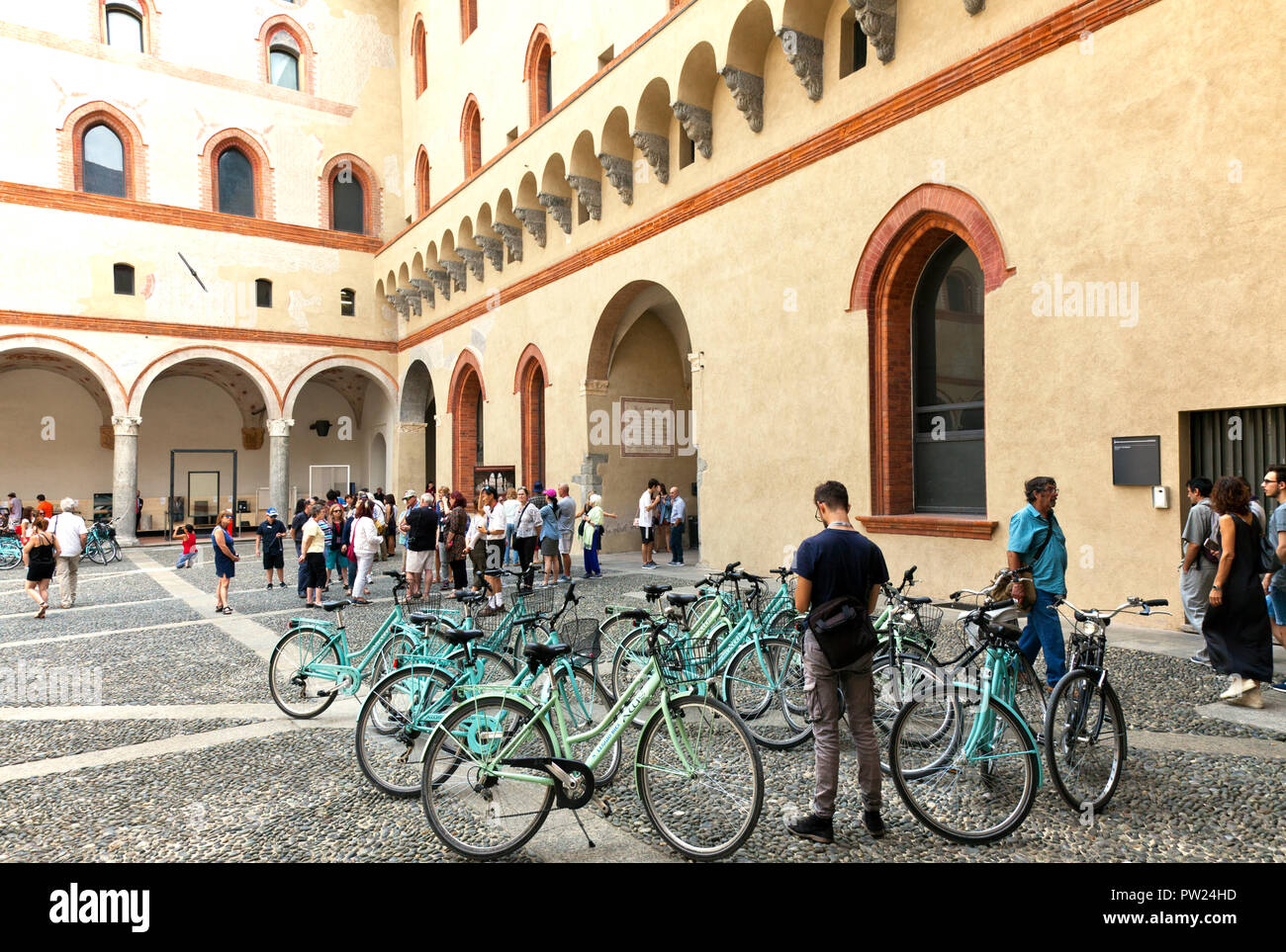 Persone e noleggio biciclette in un cortile interno di Milano Castello Sforzesco (Italiano: il Castello Sforzesco). Fu costruita nel XV secolo da Francesc Foto Stock