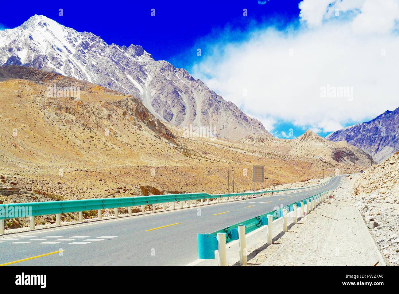 Le condizioni della strada del Karakoram Highway (Cina) Sezione nello Xinjiang e la splendida vista panoramica delle innevate sullo sfondo di montagna. Foto Stock