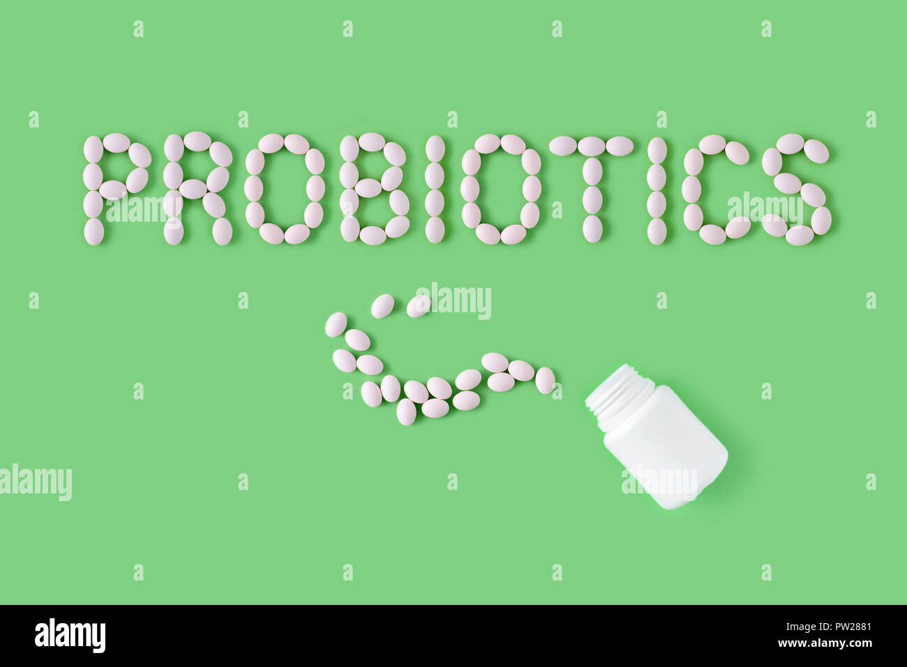 Probiotici parola fatta di pillole su sfondo verde. Appartamento laico, vista dall'alto, copia gratuita dello spazio. Foto Stock