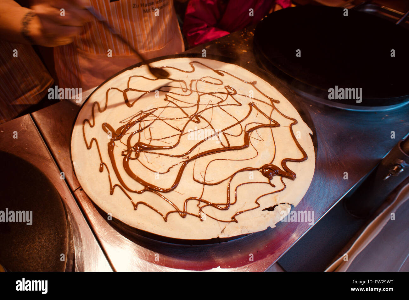 Rendendo le crepes con crema di cioccolato al più famoso mercatino di Natale di Colonia accanto al patrimonio mondiale la cattedrale di Colonia. Foto Stock