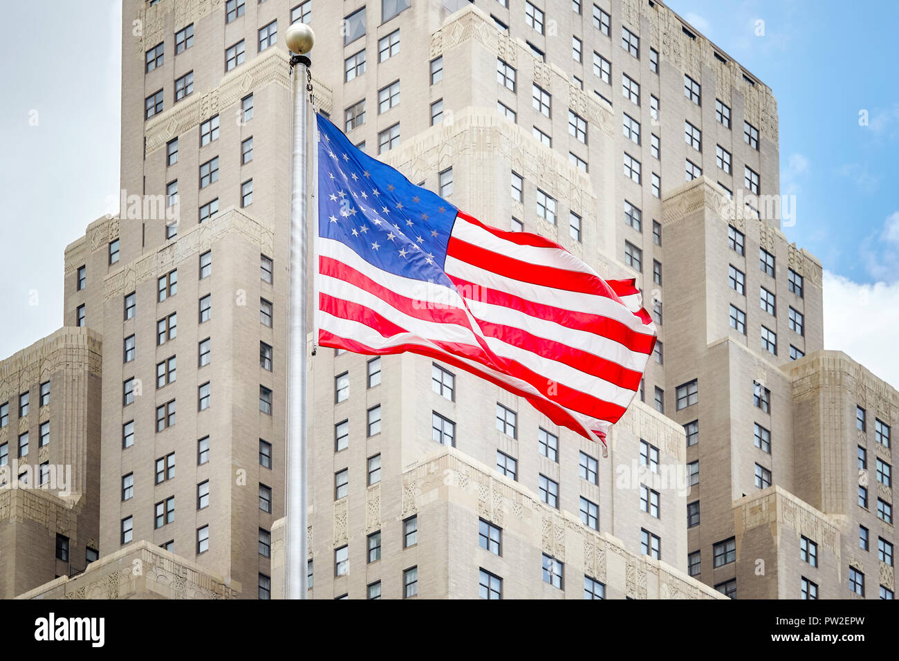 Bandiera americana con un vecchio edificio in background, New York City, Stati Uniti d'America. Foto Stock