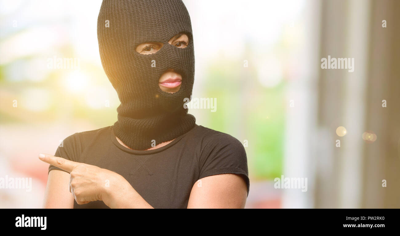 Ladro terrorista donna che indossa passamontagna maschera da sci rivolto  lontano lato con un dito Foto stock - Alamy