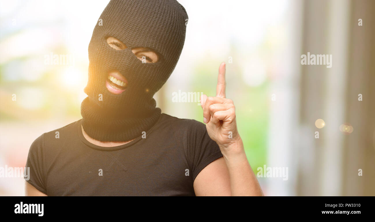 Ladro terrorista donna che indossa passamontagna maschera da sci rivolto  lontano lato con un dito Foto stock - Alamy