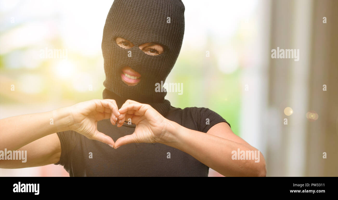Ladro terrorista donna che indossa passamontagna maschera da sci che mostra  felice amore con le mani a forma di cuore che esprimono un sano e simbolo  del matrimonio Foto stock - Alamy