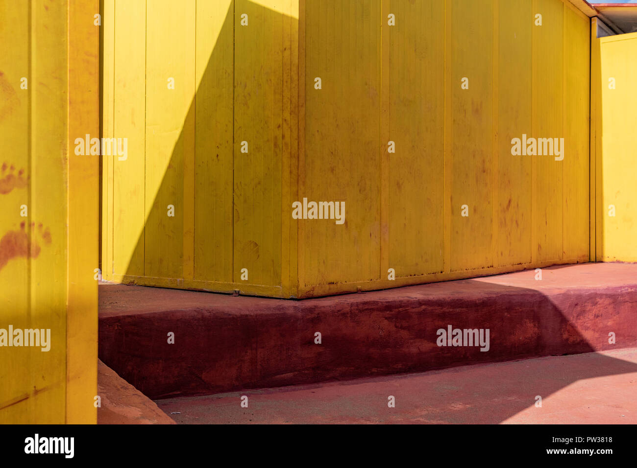 Bel colore giallo case balneare sulla spiaggia sabbiosa. Rifugi vuota su un soleggiato ma moody giorno. Architettura balneare, vernice colorata, del tipo a labirinto labyrint. Foto Stock