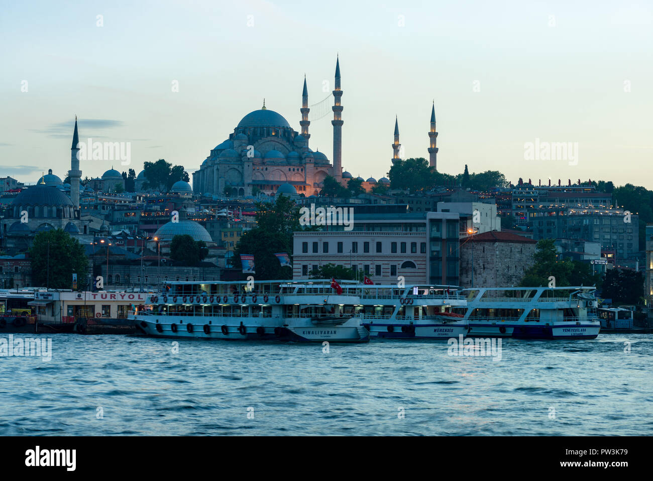 La moschea di Suleymaniye e docked traghetti a Eminonu porto al tramonto, Istanbul, Turchia Foto Stock