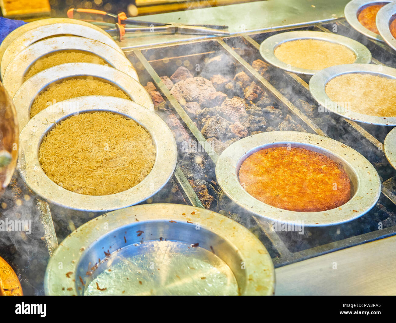 Kunefe, noto anche come Kenafeh, un tradizionale araba dolce fatto con Kadayif, una sottile sfoglia noodle, su una griglia a carbone di una bancarella di strada. Istanbul. Foto Stock