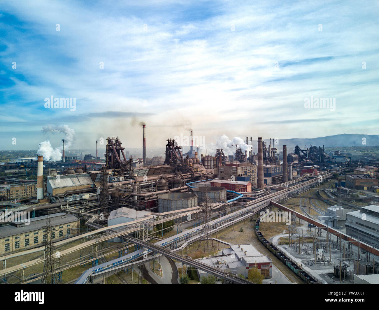 Drone vista aerea del sistema dei trasporti di industria pesante impianto; inquinamento dell aria e fiume nella città di provincia a causa di esportazione di prodotti siderurgici per grandi Foto Stock