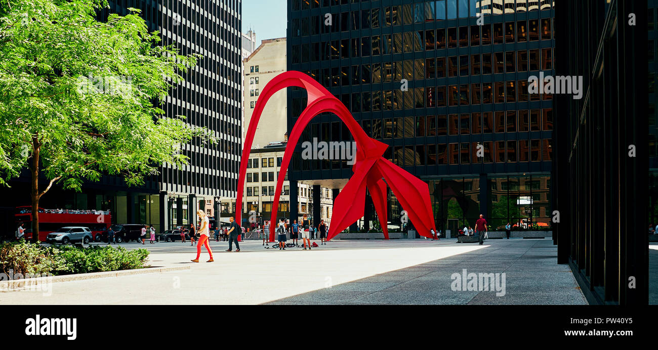 Calder Flamingo della scultura nel mezzo della vibrante luogo pubblico, Federal Plaza, a Chicago, racchiuso da alto-aumento edifici per uffici Foto Stock