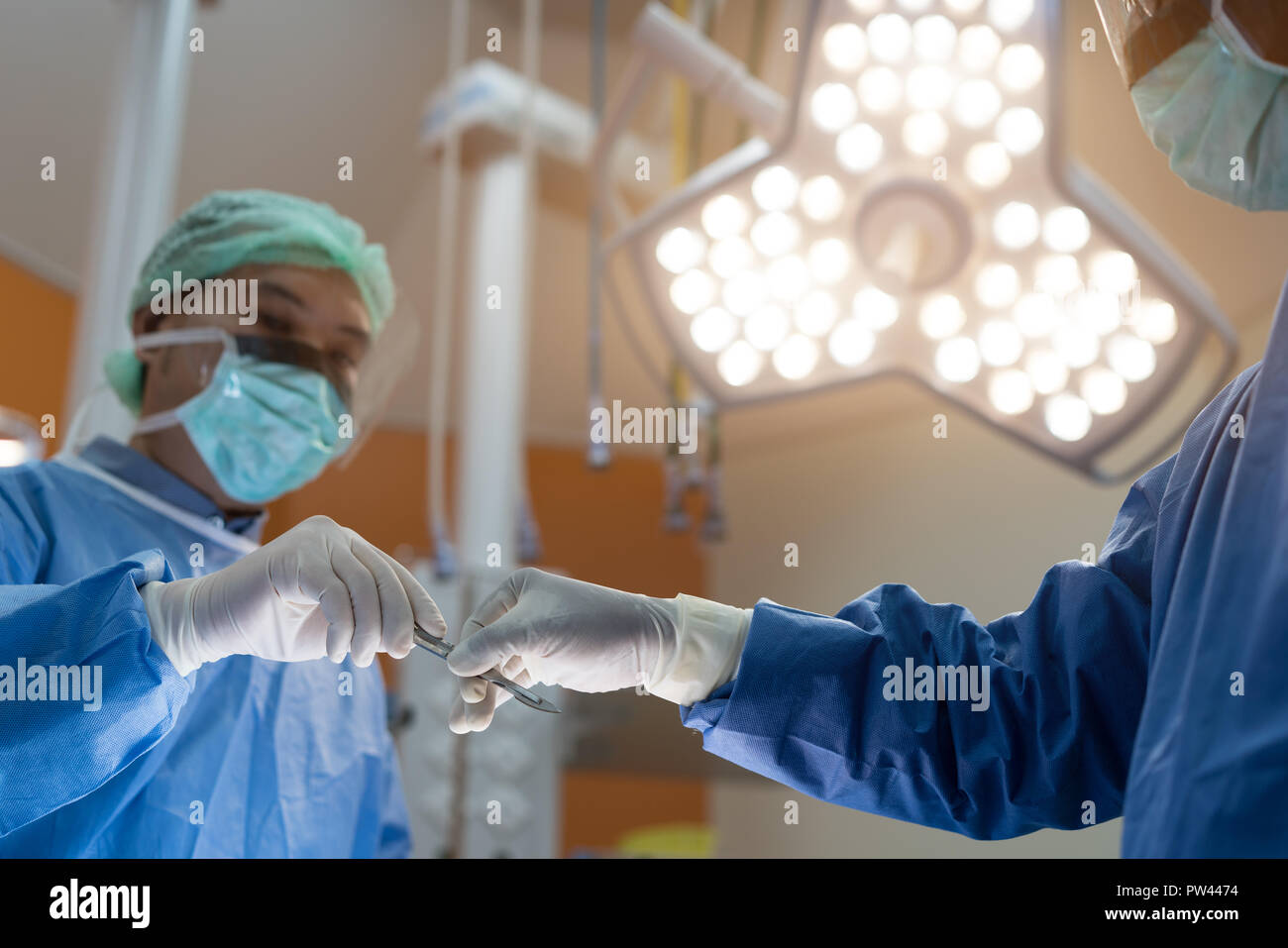 Asian medico e un assistente in sala operatoria per chirurgia vascolare venosa clinica di chirurgia in ospedale. Foto Stock