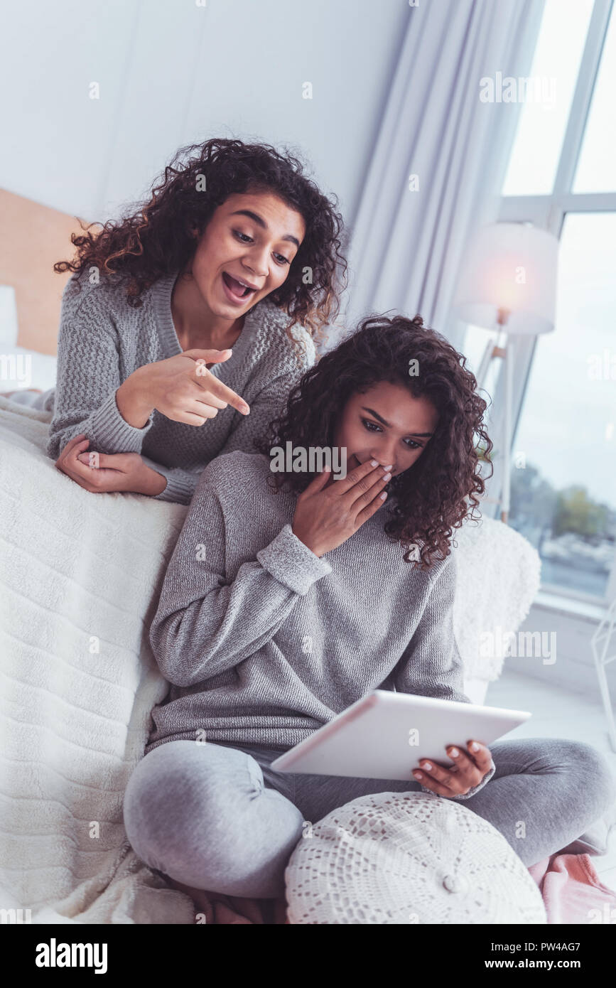 Due amici sentirsi sorpreso dopo la lettura di bellezza curioso articolo Foto Stock