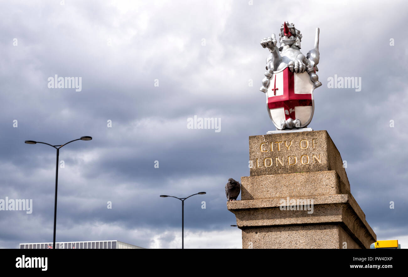 Basso angolo vista della statua del drago con scudo e St George cross contro il cielo nuvoloso Foto Stock