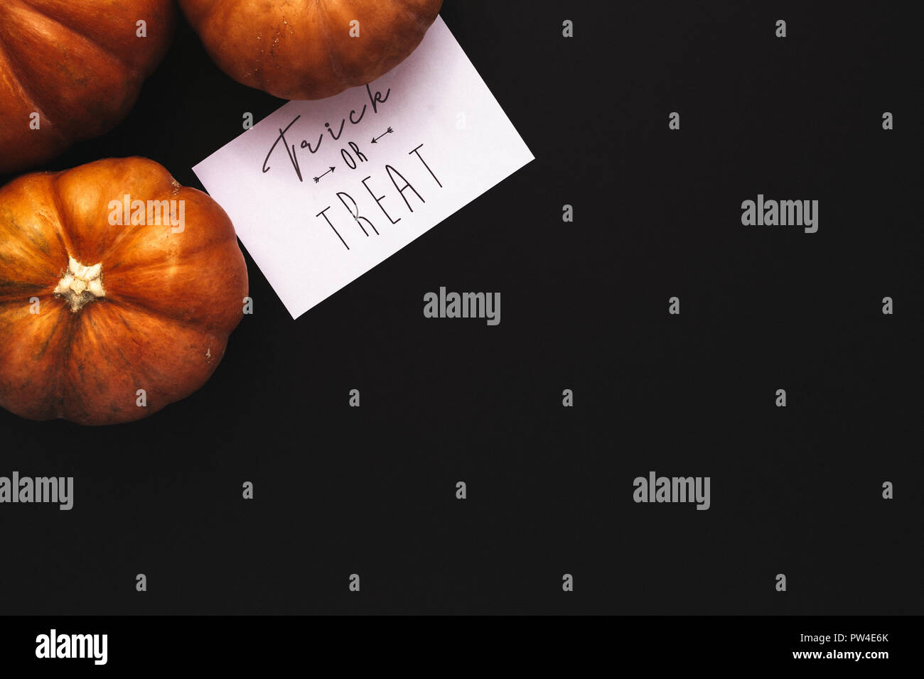 Zucche e Dolcetto o scherzetto scheda con copia spazio su sfondo nero. Halloween piana concetto laici. Foto Stock