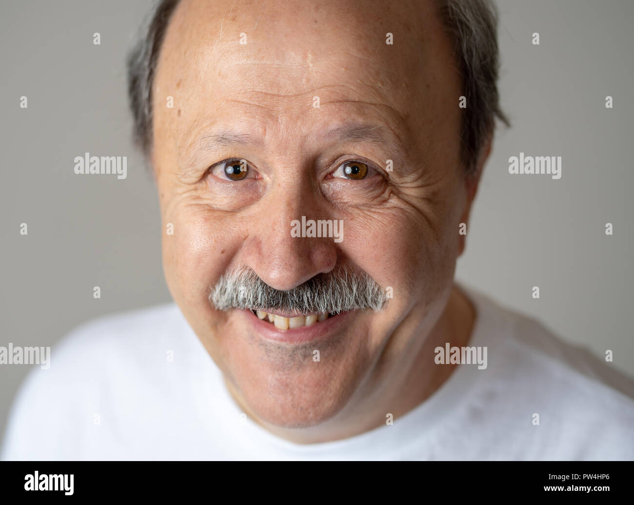 A sorridere e ridere 60s anno vecchio uomo senior candide close up ritratto in emozioni umane e le espressioni del viso concetto isolato in uno sfondo neutro. Foto Stock