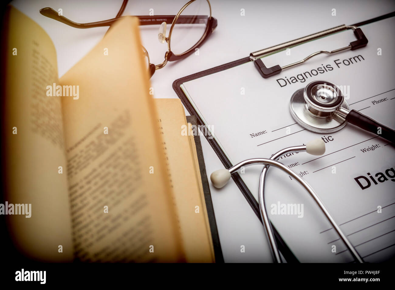 Forma di diagnosi accanto a una vecchia cartella di lavoro a uno stetoscopio, immagine concettuale Foto Stock