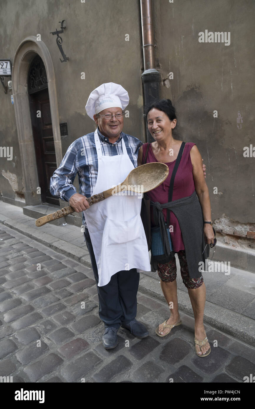 Città Vecchia (Stare Miasto), Varsavia, Polonia. Ristorante rappresentante sulla strada regia prospective diners per il suo ristorante. Foto Stock