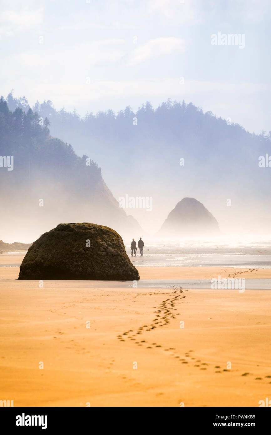 Un giovane lascia impronte nella sabbia vicino abbraccio punto sulla costa dell'Oregon, Stati Uniti d'America. Foto Stock