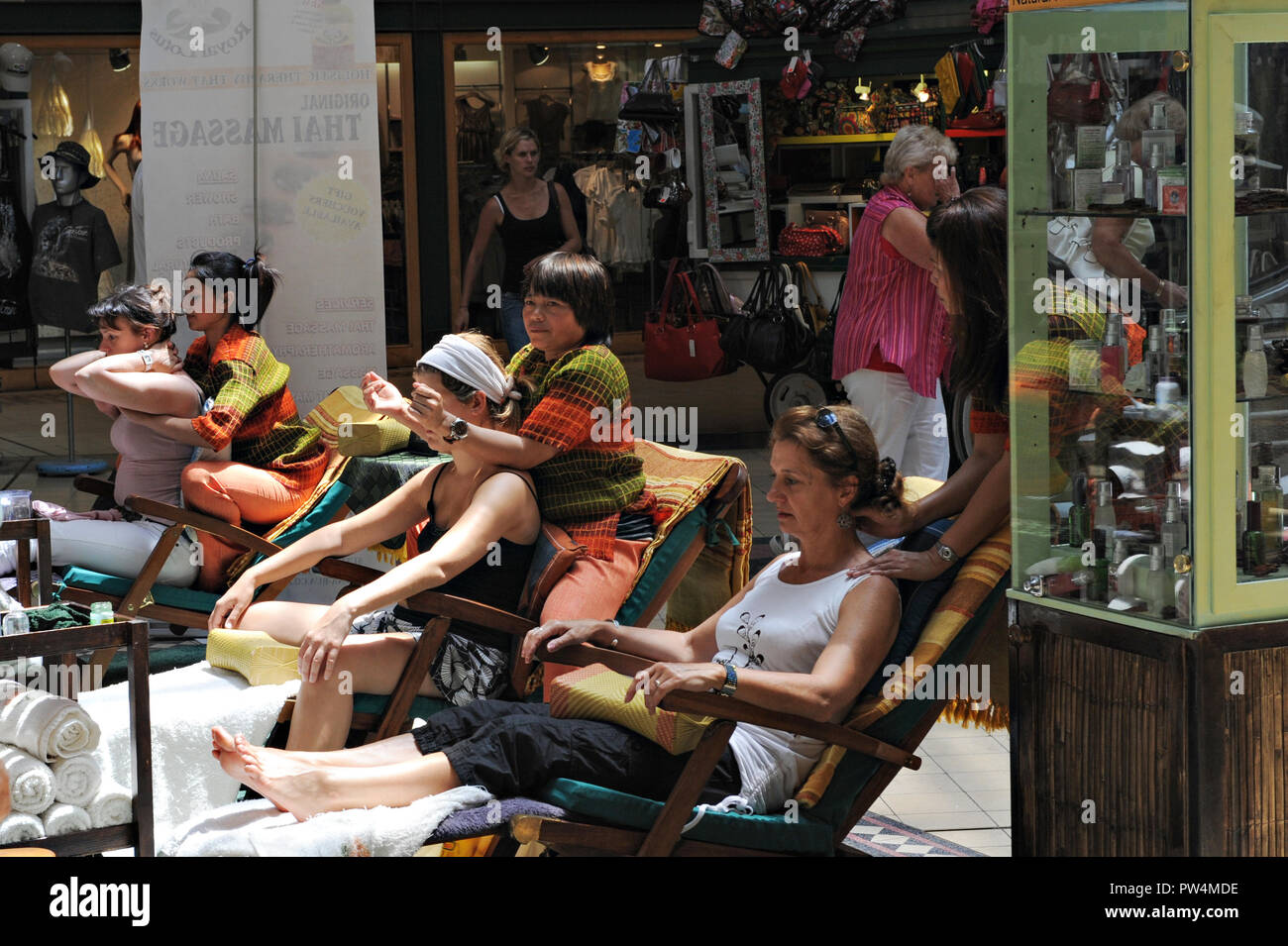 Le persone aventi il massaggio Thai presso il centro commerciale Victoria Wharf a Città del Capo in Sud Africa Foto Stock