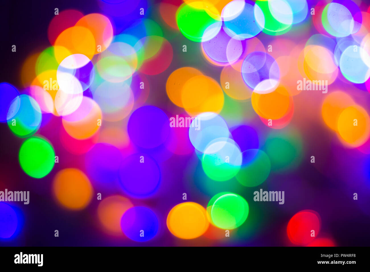 Natale e Anno Nuovo concetto - Defocalizzata abstract multicolori luci bokeh sfondo. Blu, viola, verde, arancione. Foto Stock
