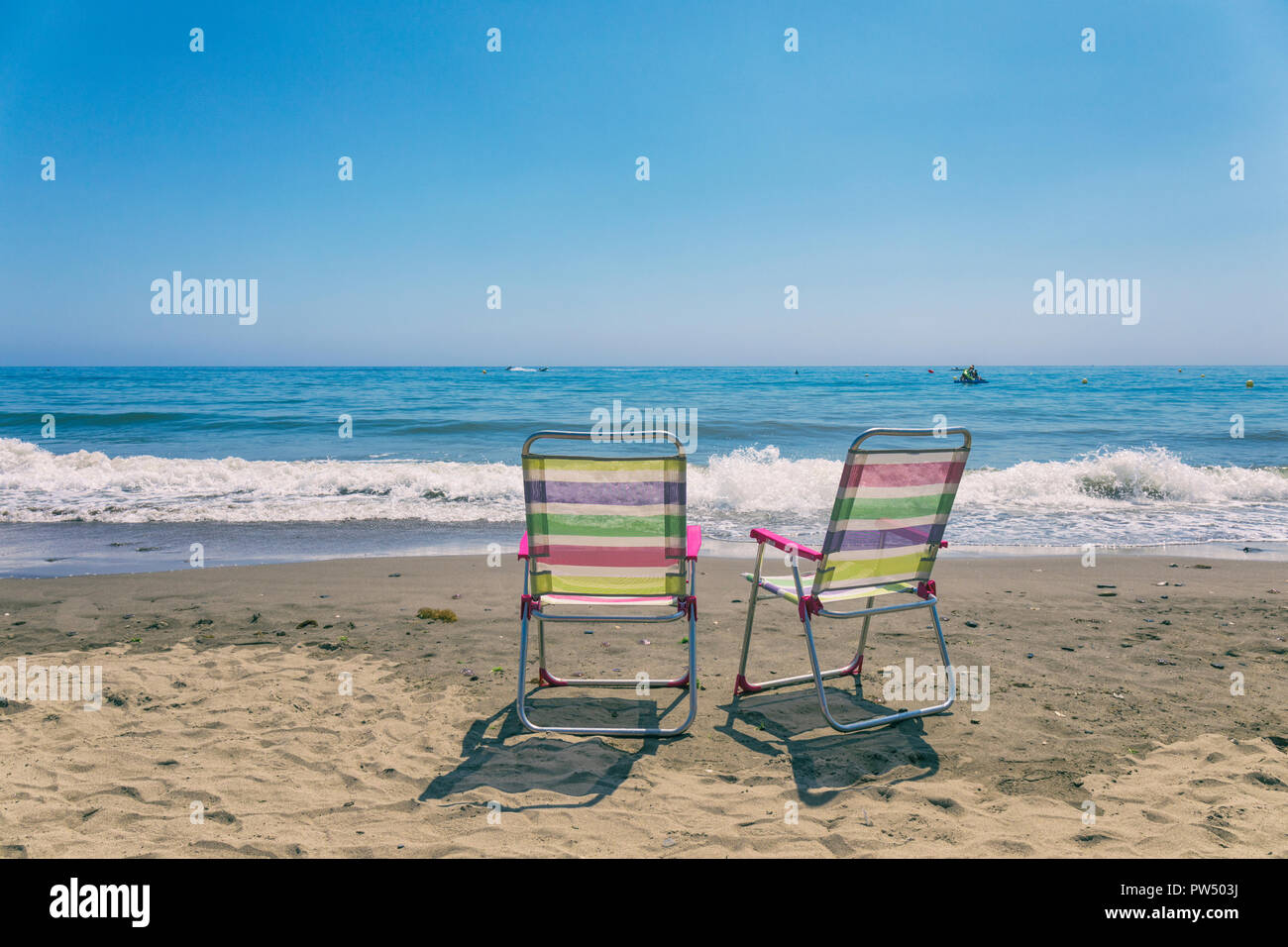Due sedie vuote in riva al mare. Foto Stock