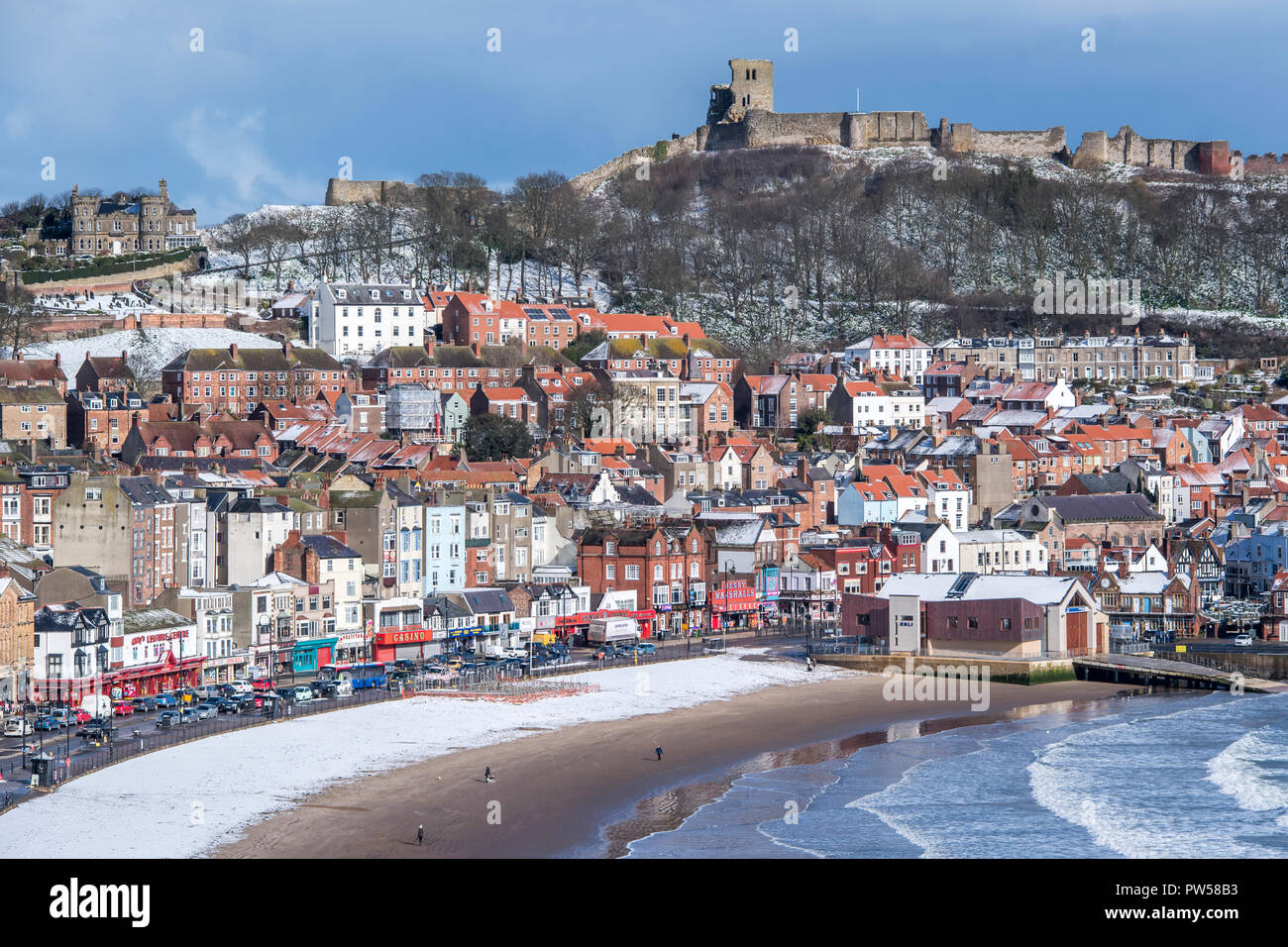 Castello di Scarborough e la spiaggia sono coperti di uno strato sottile di neve durante la bestia da est eventi meteo Foto Stock