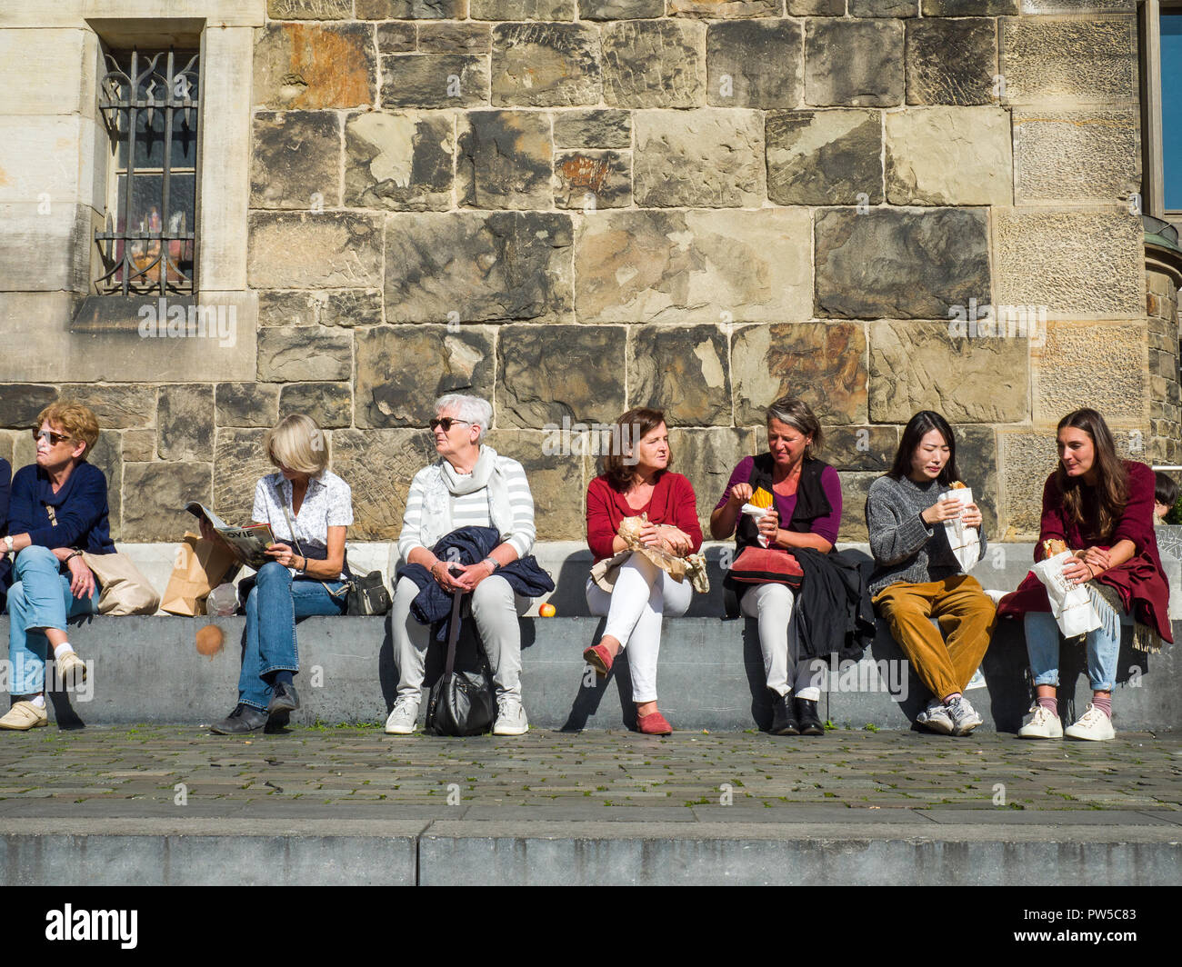 Turistica di appoggio alle donne durante la pausa pranzo in Aachen città storica, Germania. Foto Stock