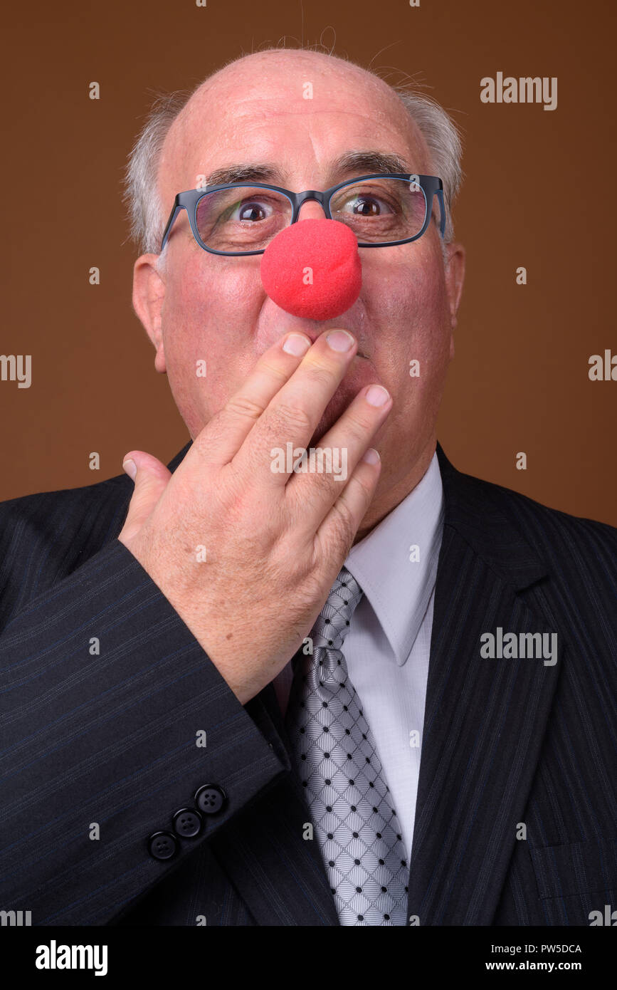 In sovrappeso imprenditore senior indossando red clown naso Foto Stock